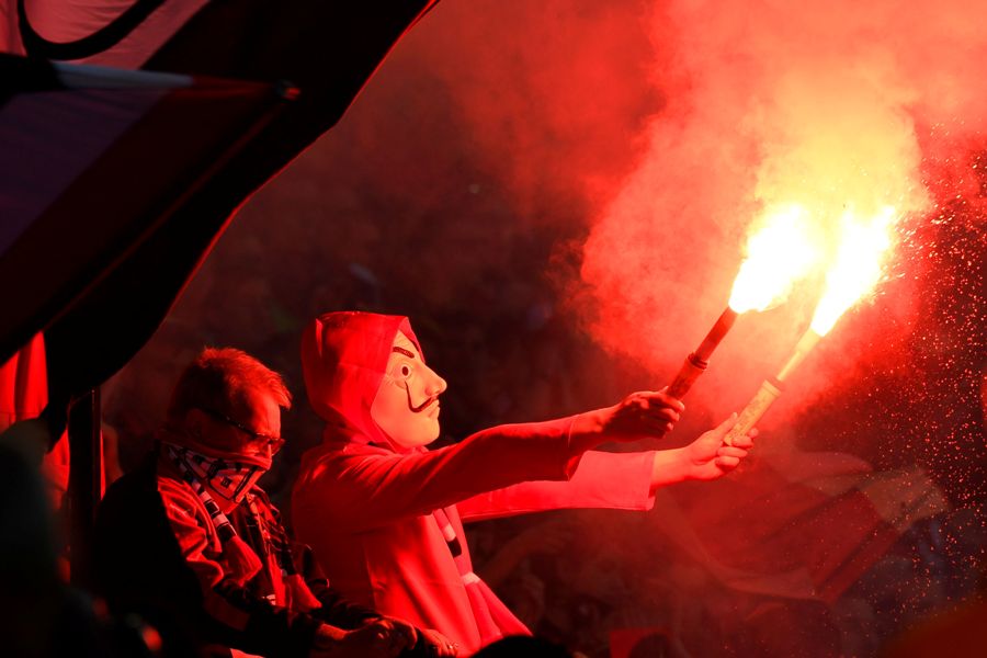 Un hincha de Rennes usa bengalas encendidas durante el partido de fútbol francés.
