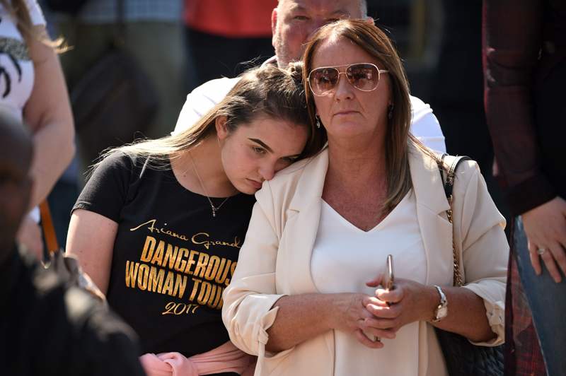 La gente se reúne frente a la Catedral de Mánchester mientras se ofrece un servicio para recordar a las víctimas de los atentados del año pasado. (AFP