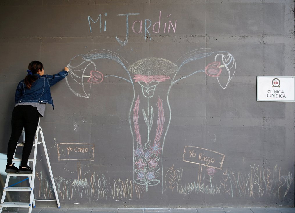 Una estudiante de la Universidad Nacional Andrés Bello termina un mural de un útero para exigir el fin del sexismo y la violencia de género, en Viña d