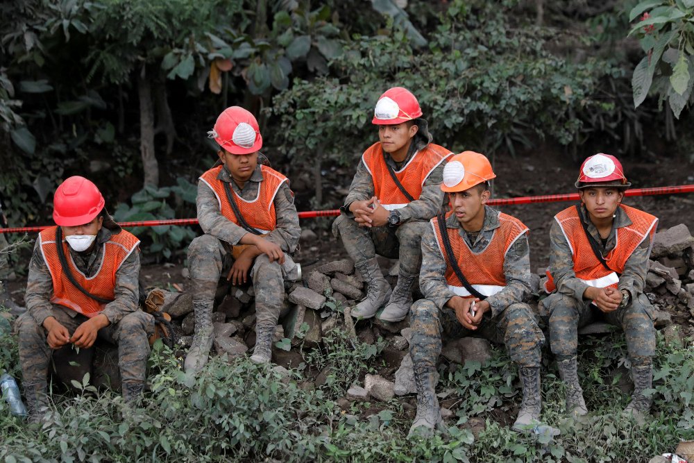 Rescatistas toman un descanso durante las labores de búsqueda tras el desastre causado por el Volcán de fuego. (Reuters)