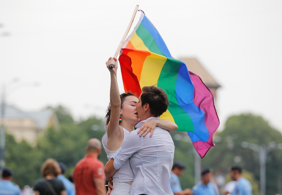 Dos chicas se besan sosteniendo una bandera del arco iris durante el desfile del orgullo gay en Bucarest. (AP)
