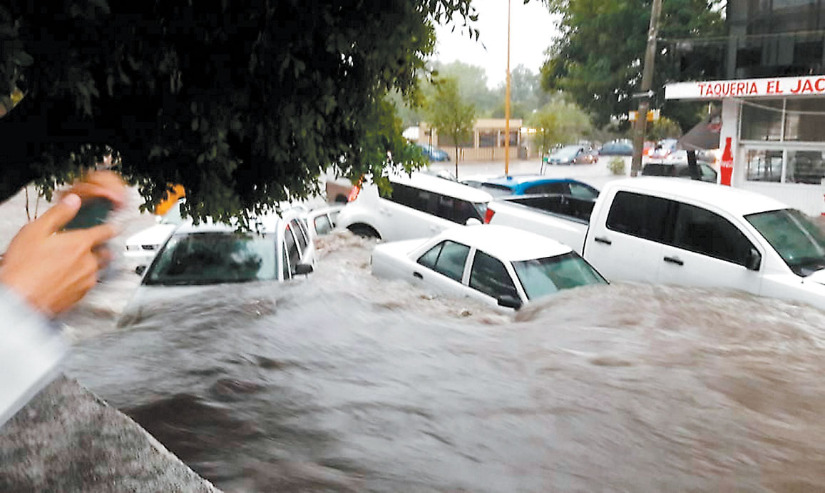 Vehículos arrastrados por las corrientes que se formaron en calles de la capital aguascalentense. (Especial)