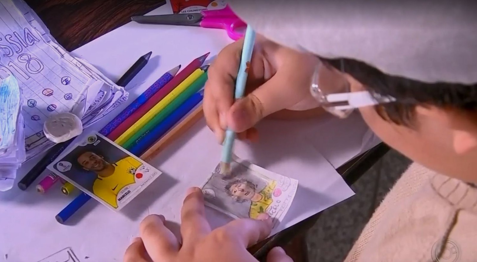 Pedro dibujando su álbum del Mundial 2018 (O Globo)