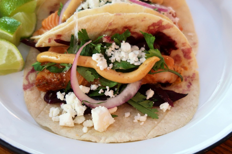 Lleva salmón confitado y marinado, chile ahumado, chipotle, aceite de oliva, cebollitas y cilantro, todo aderezado con mayonesa de chipotle