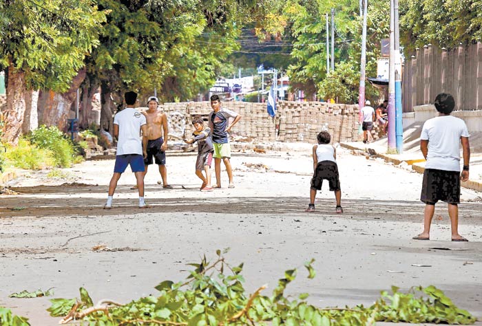 Niños juegan al beisbol entre barricadas, en la rebelde ciudad de Masaya. (Foto: Marvin Recinos/AFP)
