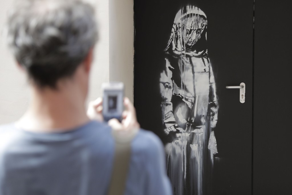 Unoa de las obras de Banksy, cerca del Batalcán, lugar de los atentados del 13-N (Foto: AFP)