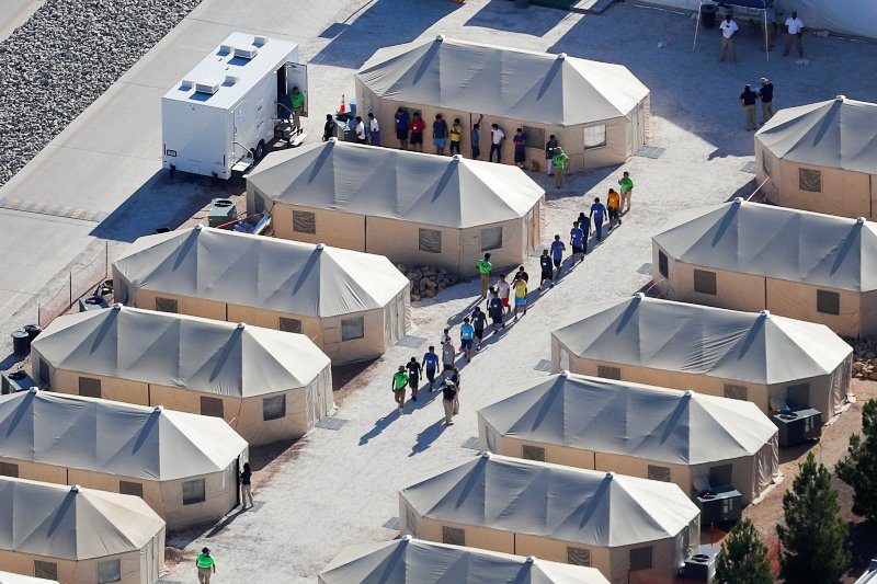 Niños migrantes en un campamento caminan en fila en Tornillo, Texas.