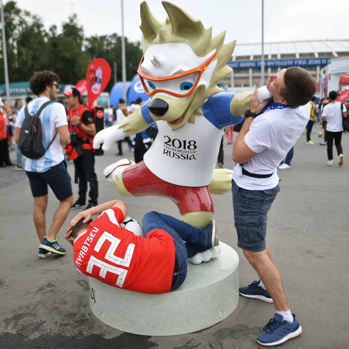 Aficionados posan con estatua de Zabivaka, la mascota del Mundial de Rusia 2018 (AFP)