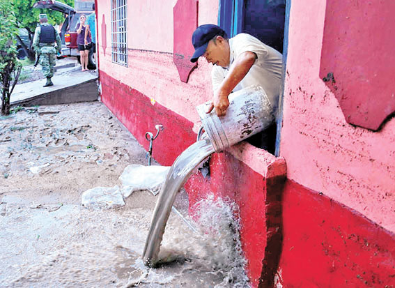 Vecino de la colonia Victoria, Matamoros, saca agua de su casa anegada. (Miguel Ángel González)