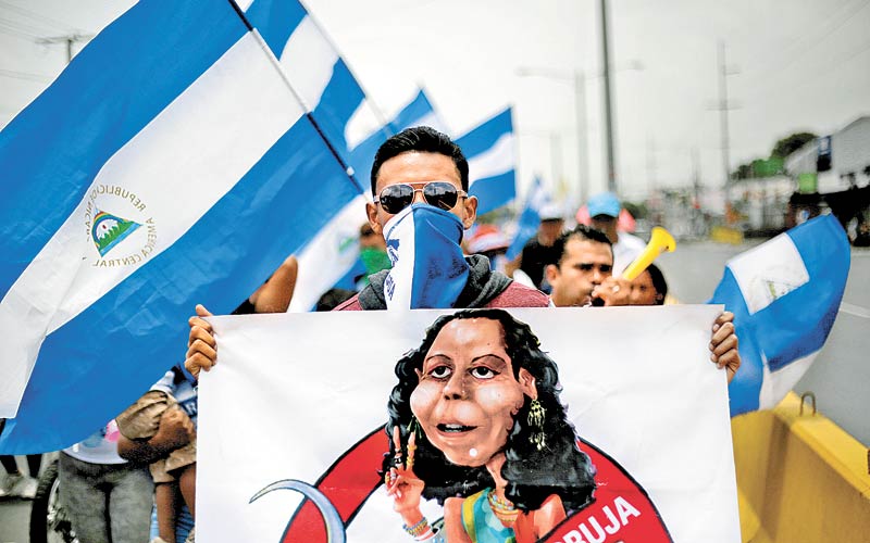 Un manifestante este domingo en Managua, con un cartel que ilustra a la primera dama y vicepresidente Rosario Murillo. (Foto: Jorge Cabrera/Reuters)