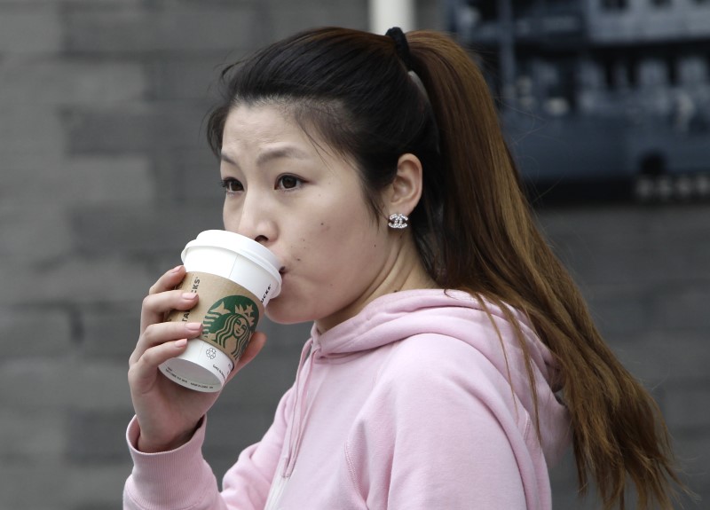 Una mujer bebiendo desde un vaso de café de Starbucks en el centro de Pekín. (Foto: Reuters)
