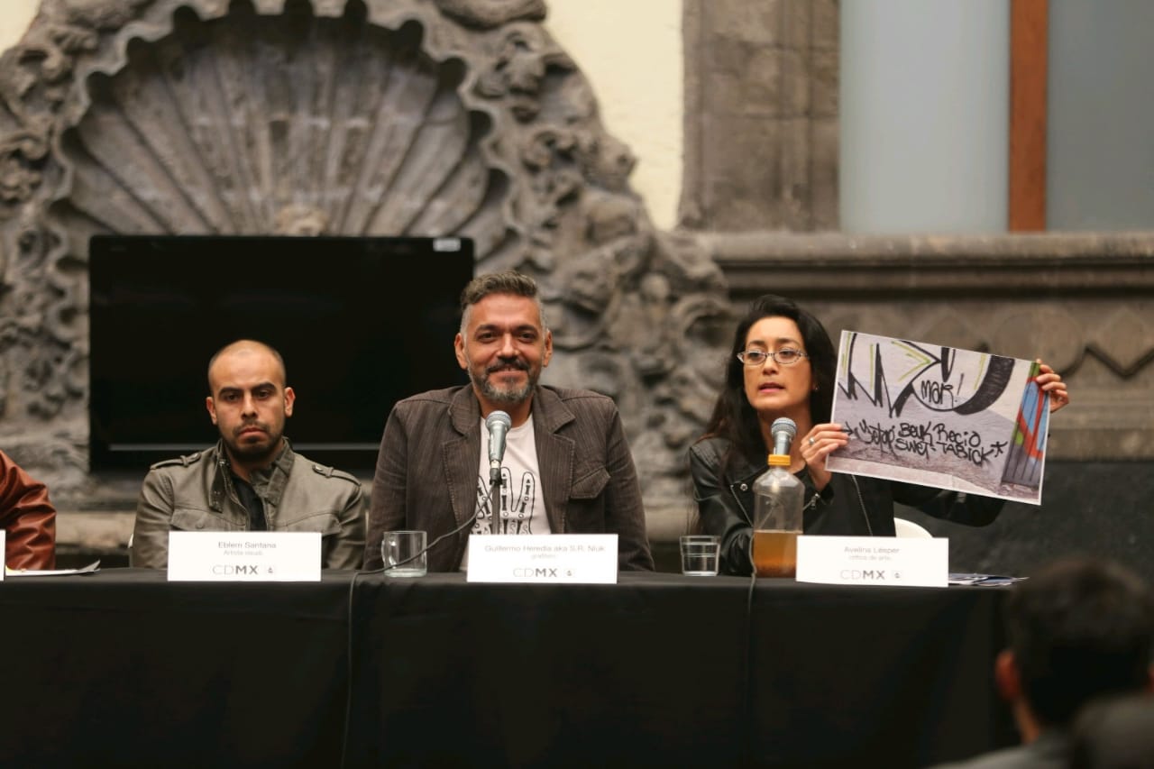 Los artistas gráficos Eblem Santanta y Guillermo Heredia junto a Avelina Lésper en el Museo de la CdMx. (Foto: Javier Ríos | MILENIO)