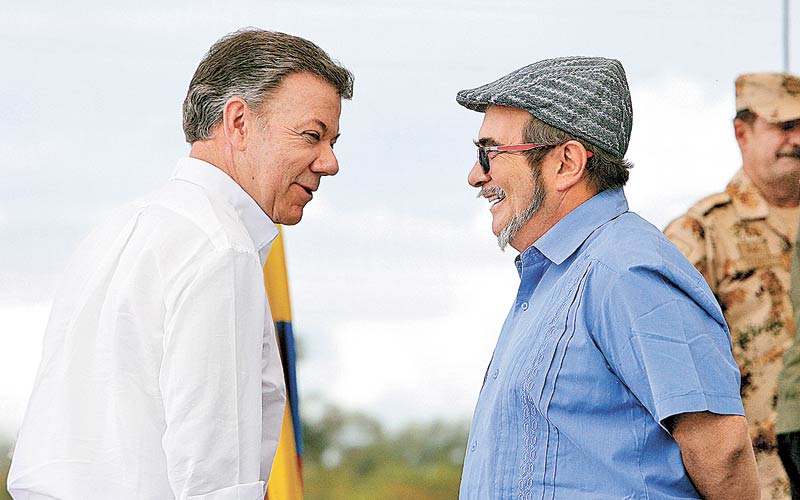 Santos (i) platica con 'Timochenko', líder de las FARC, en la ceremonia de entrega de armas en junio de 2017. (Mauricio Dueñas/EFE)