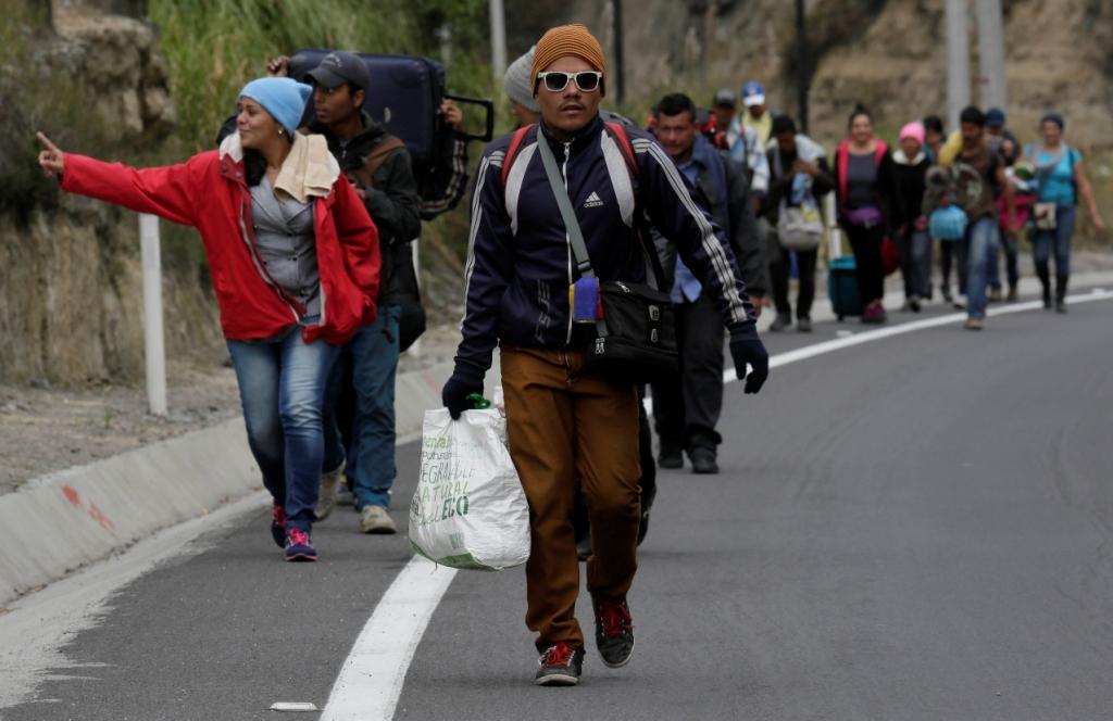 Venezolanos sin pasaporte caminan por una carretera después de cruzar el puente internacional Rumichaca desde Colombia para dirigirse a Ecuador. (AP |