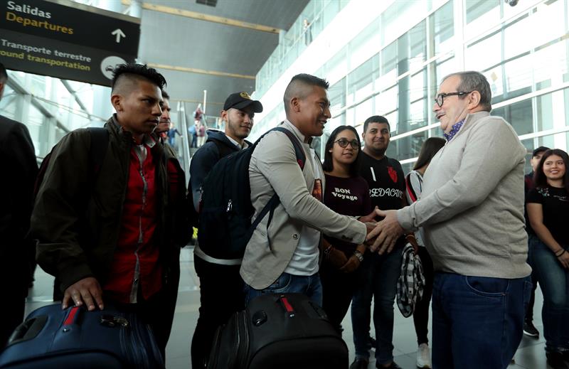 El máximo líder de las extintas FARC, Rodrigo Londoño (d), estrecha la mano de un ex guerrillero en el aeropuerto El Dorado, de Bogotá.