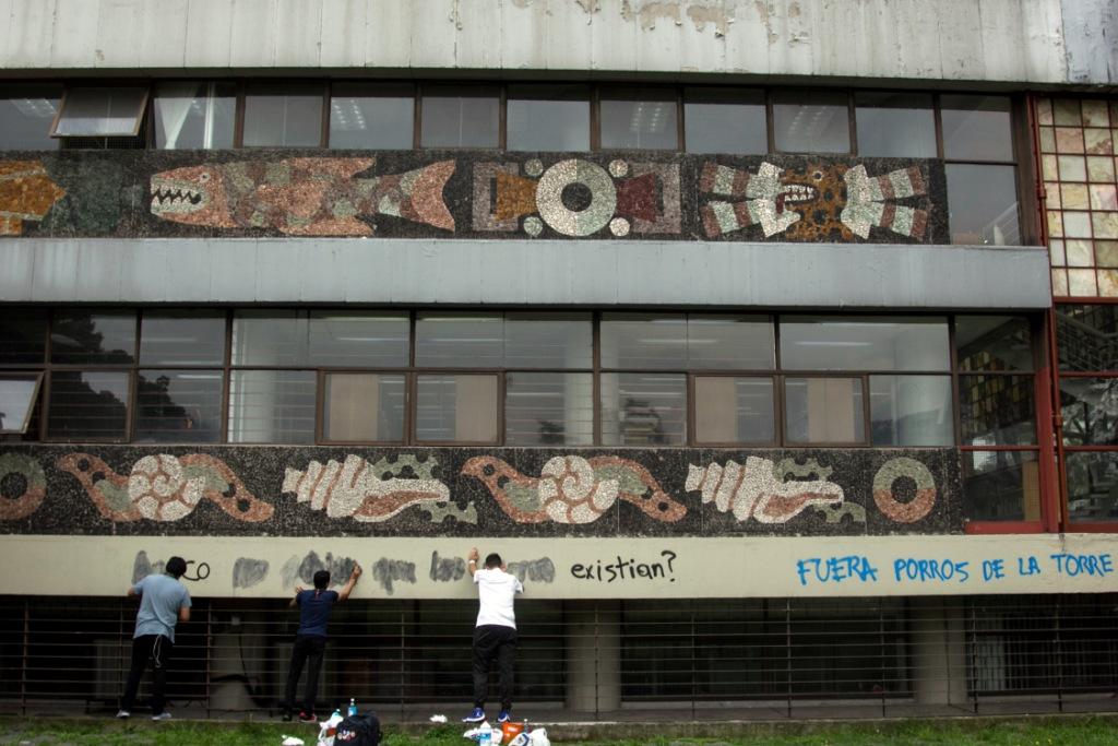 Con estopa, guantes y tinner  estudiantes borraron consignas pintadas en la biblioteca que exigían la salida de los porros.  (Cuartoscuro)