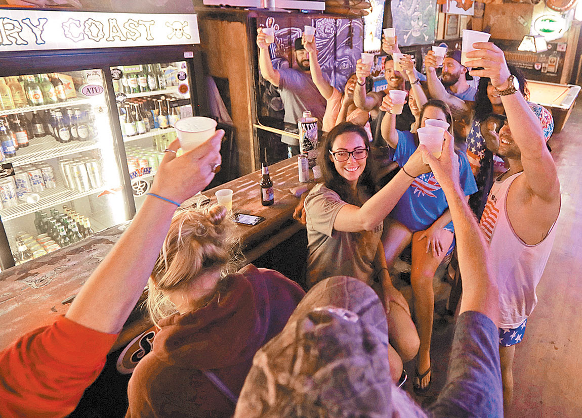 Habitantes de Wilmington, Carolina del Norte, brindan por el temporal en un bar del centro del pueblo costero. (Chuck Burton/AP)