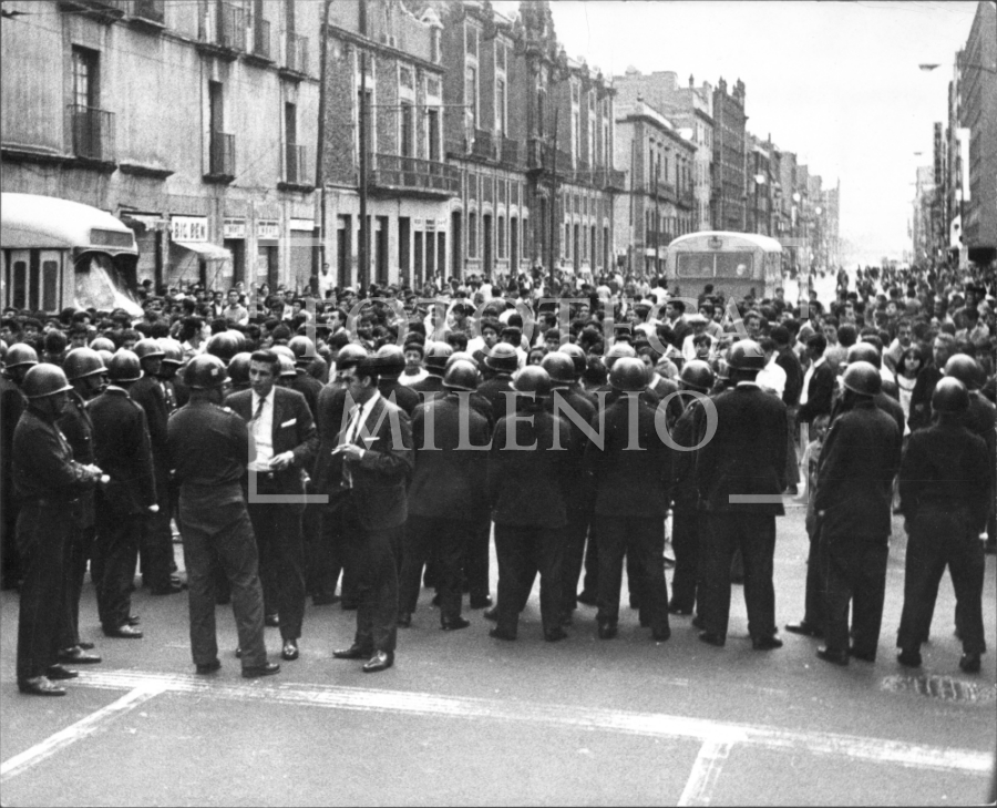 Soldados enfrente de civiles en una calle del Centro en agosto de 1968. (Fototeca MILENIO)