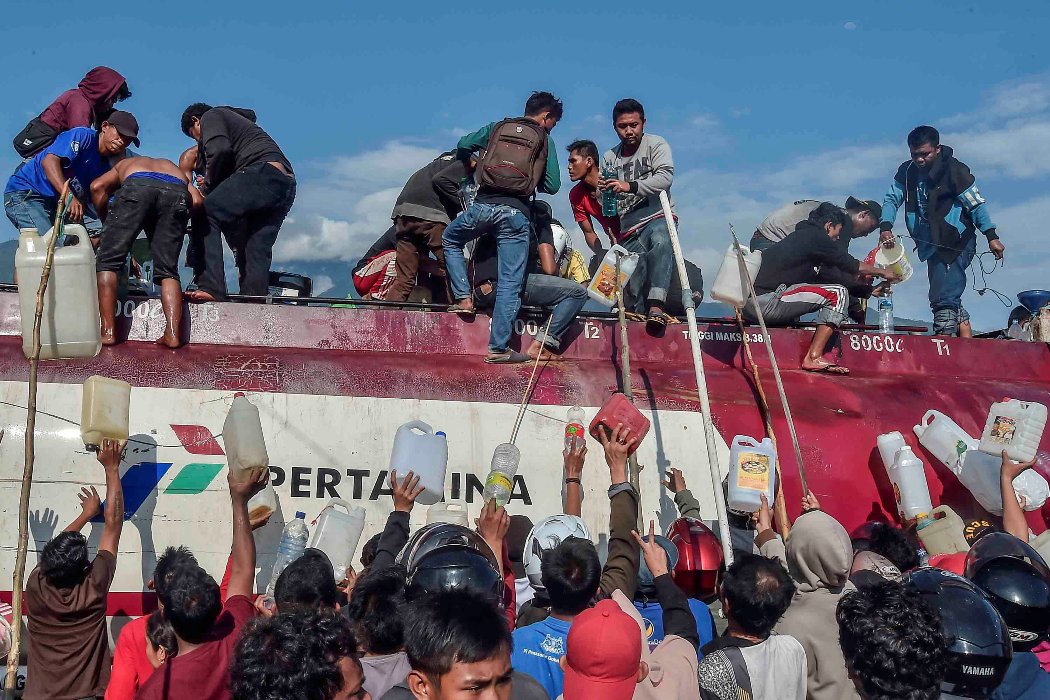 La muchedumbre llena bidones, botellas e incluso cacerolas con combustible. (Reuters)