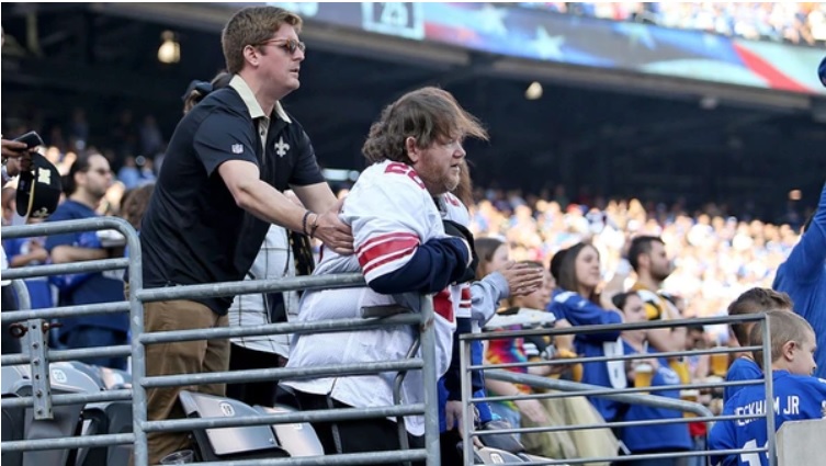 Foto de dos aficionados durante el himno, previo al choque entre los Saints y los Giants (NOLA.com)