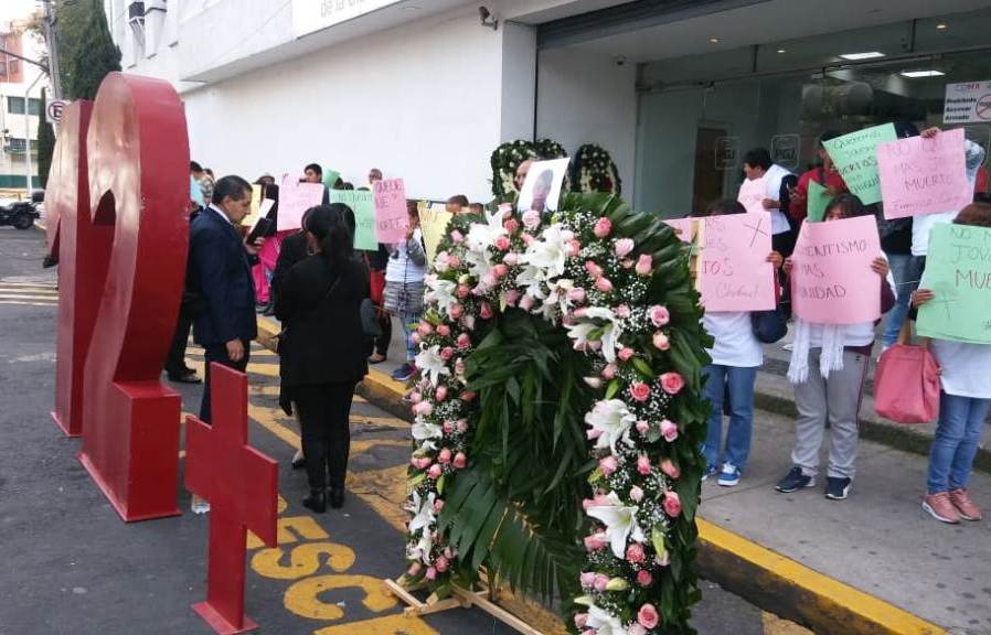 Los familiares de las 12 víctimas colocaron arreglos florales y un número 12 en la entrada de la PGJ. (César Velázquez)