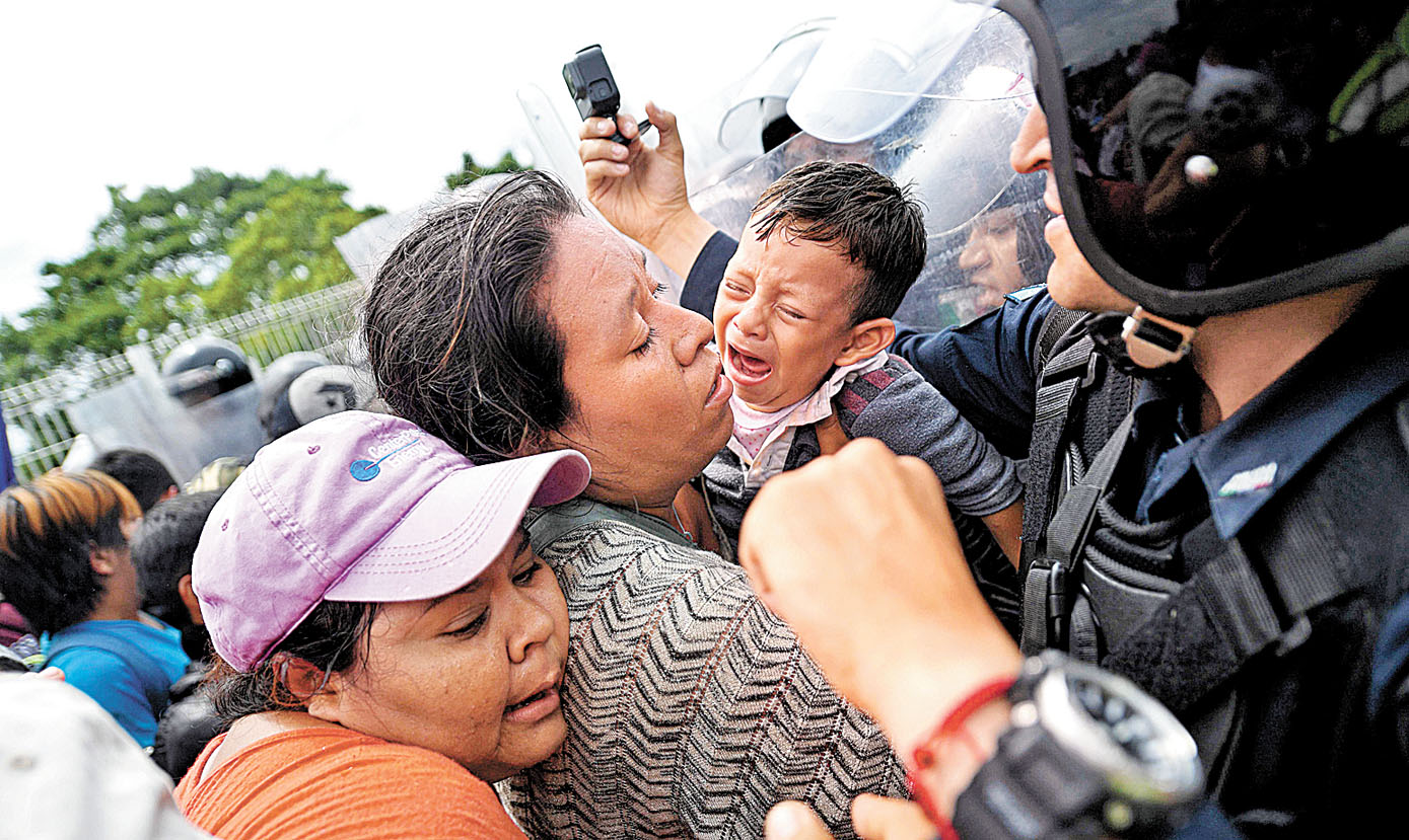 Luego de que lograron cruzar el primer retén, los migrantes ya eran esperados por policías con uniformes antimotines. (Pedro Pardo/AFP)