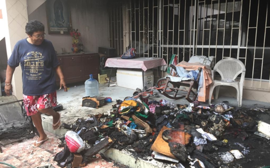 Mujer observa como el fuego consumió sus pertenencias.
