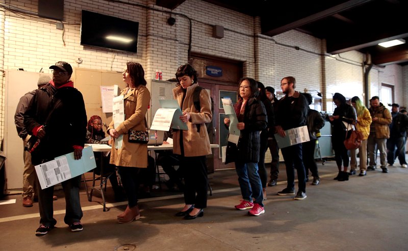 Votantes de Detroit hacen fila dentro de una estación de bomberos convertida a casilla. (Reuters)
