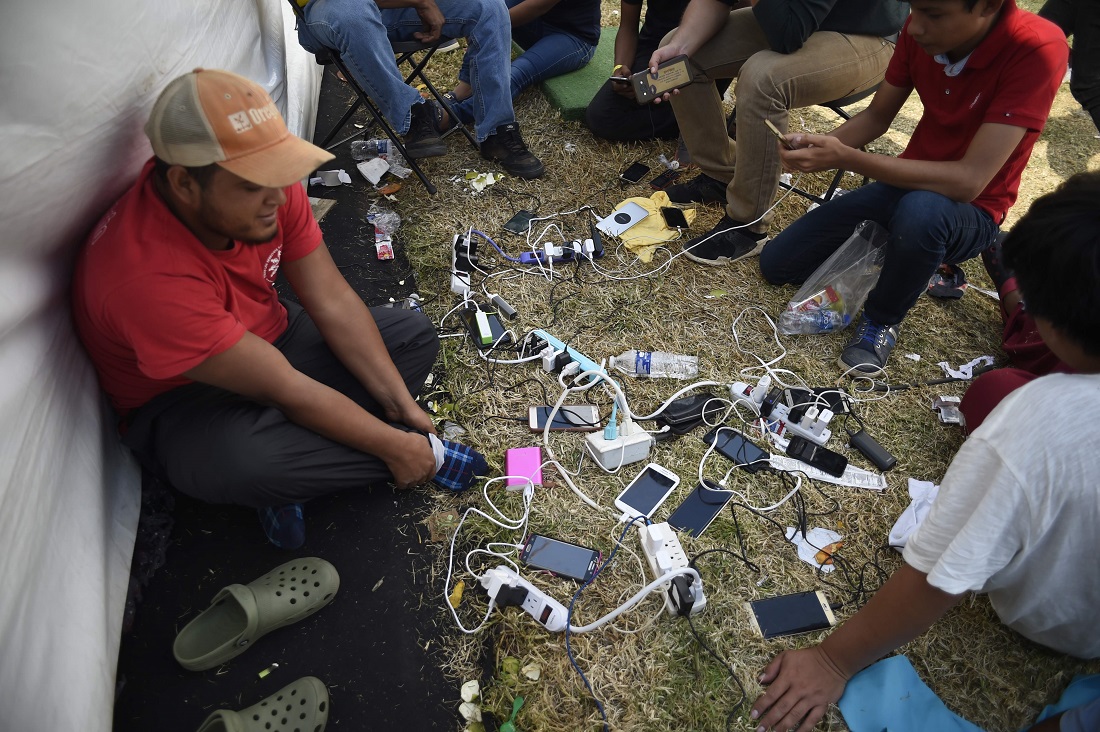 Integrantes de la caravana migrante buscan comunicarse con su familia. (AFP)