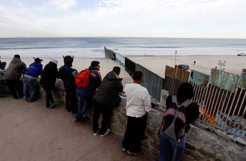 Muchos migrantes corrieron a la playa de Tijuana a bañarse y metían la cabeza entre las rejas metálicas de la frontera para divisar su destino soñado.