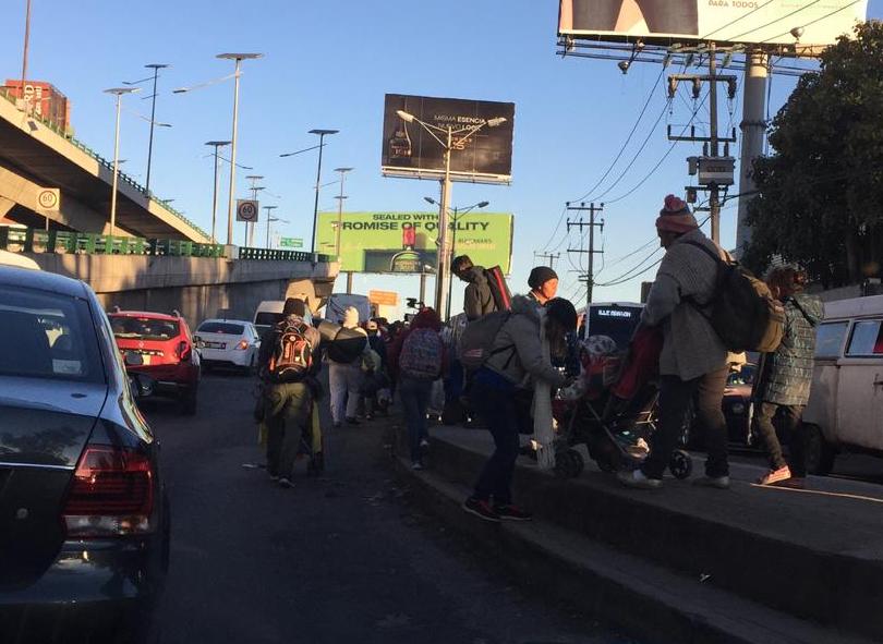 Los migrantes caminan por los carriles laterales de Periférico Norte. (Omar Brito)
