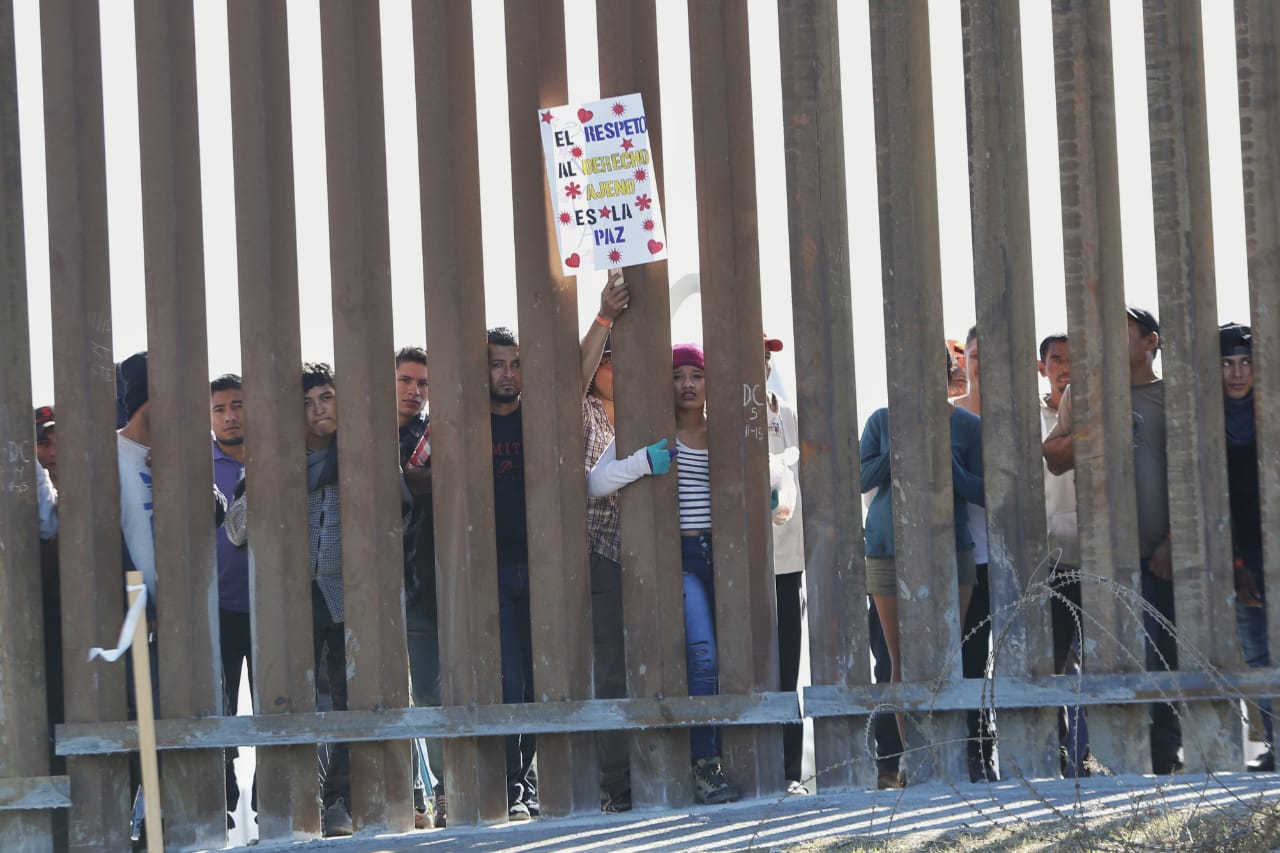 Migrantes centroamericanos en una parte de la valla fronteriza en Tijuana esperan poder ingresar a EU. (Andrés Lobato)