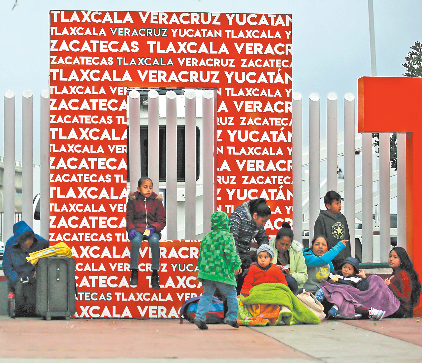 Migrantes esperan para solicitar la visa humanitaria en la oficina de El Chaparral, en la frontera de Tijuana. (AP)