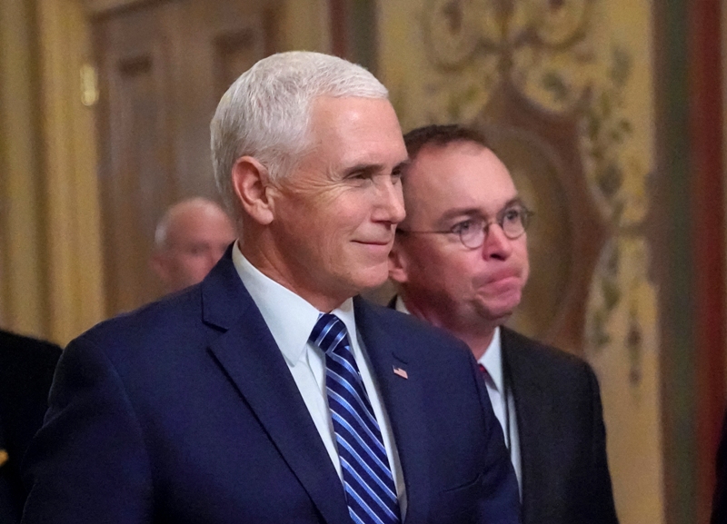 El vicepresidente Mike Pence, a la izquierda, camina junto a Mick Mulvaney durante una reunión en el Capitolio.