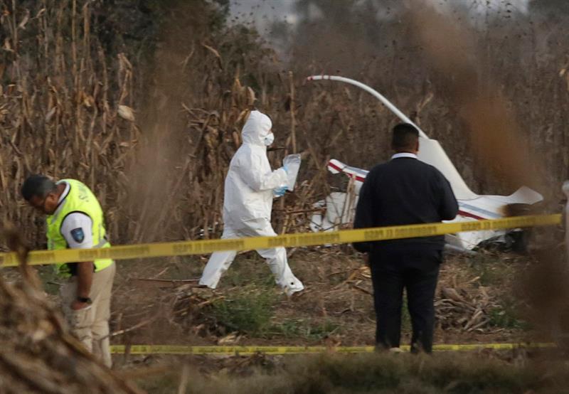 Expertos trabajan en torno a los restos de la aeronave donde viajaban la actual gobernadora de Puebla, Martha Erika Alonso,. (EFE)