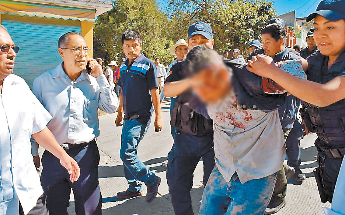 Policías someten al presunto inculpado del ataque al munícipe. (Especial)