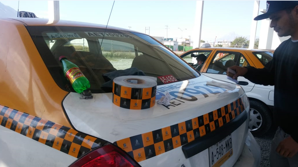 La Agencia Estatal del Transporte coloca calcas a taxistas en NL. (Foto: César Cubero)