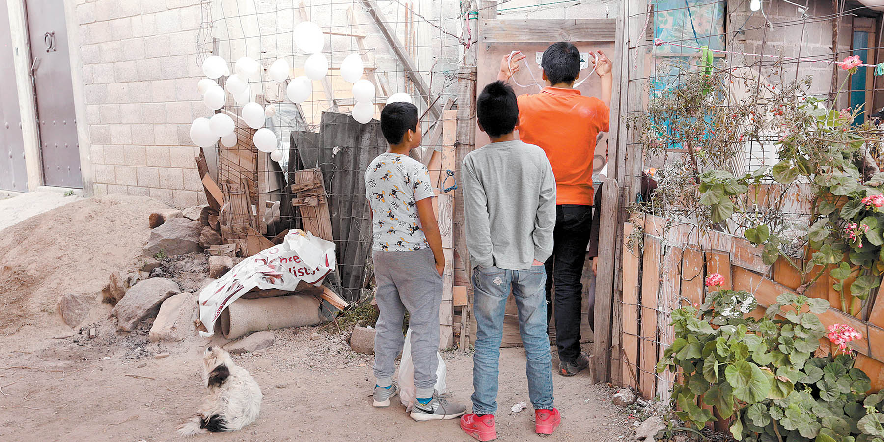 Tres menores colocan un moño blanco en señal de duelo en la casa de la niña asesinada. (Jesús Quintanar)
