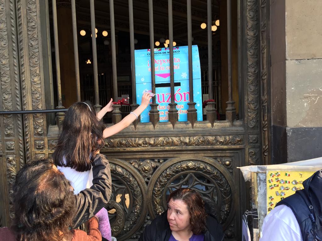 Una niña intenta enviar su carta en un buzón en Palacio Postal. (Fanny Miranda)