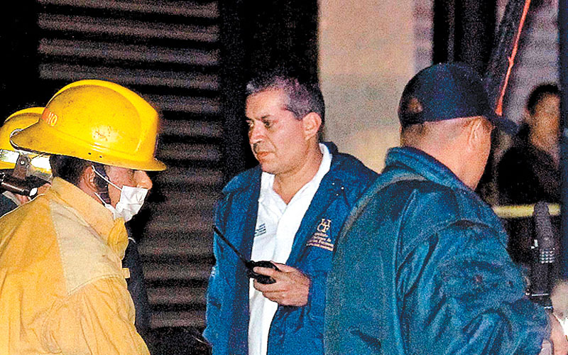 Bomberos y peritos retiran el cuerpo de una víctima en el bar de El Salto. (Ulises Ruiz/AFP)