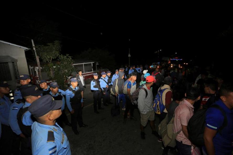 Ciudadanos hondureños pasan por un reten policial hoy, en la aduana de Agua Caliente, frontera entre Honduras y Guatemala.