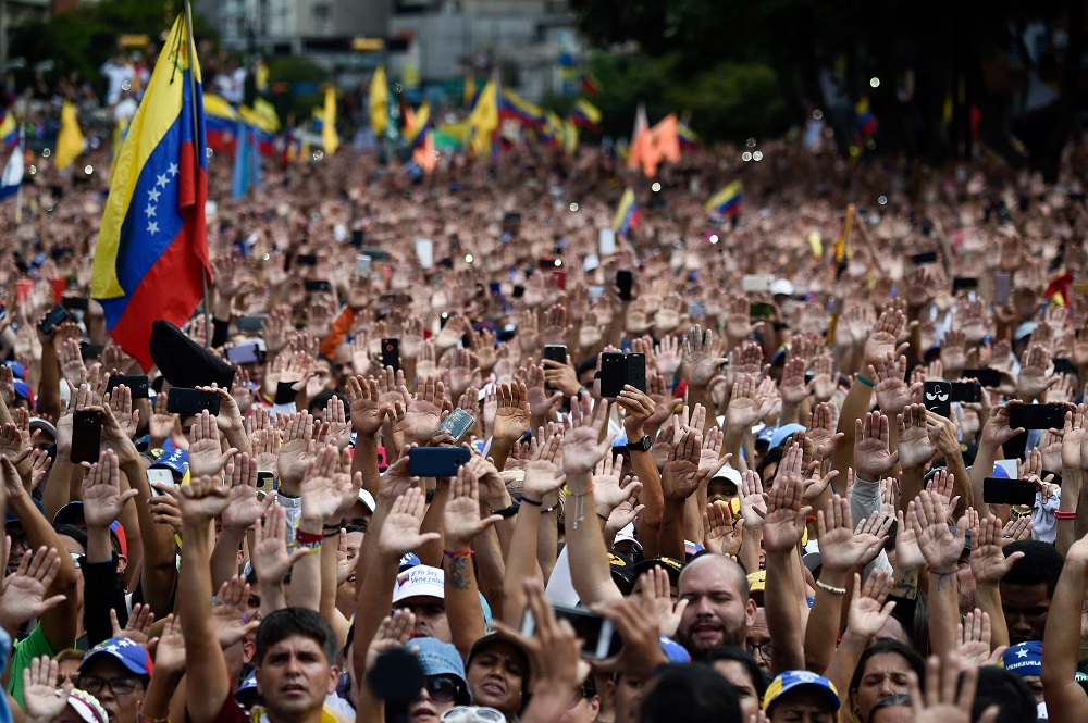 Miles de manifestantes levantan la mano para manifestar su rechazo al gobierno de Maduro. (AFP)