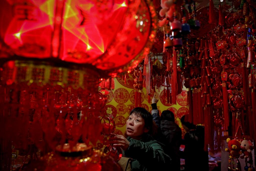 China- Una mujer escogiendo diversos adornos alusivos al Año Nuevo Chino que será el 5 de febrero / AP