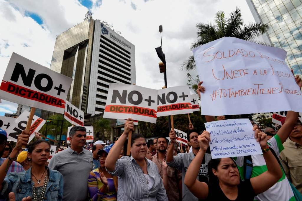 Esta protesta es custodiada por una decena de miembros de la Policía Nacional Bolivariana. AFP
