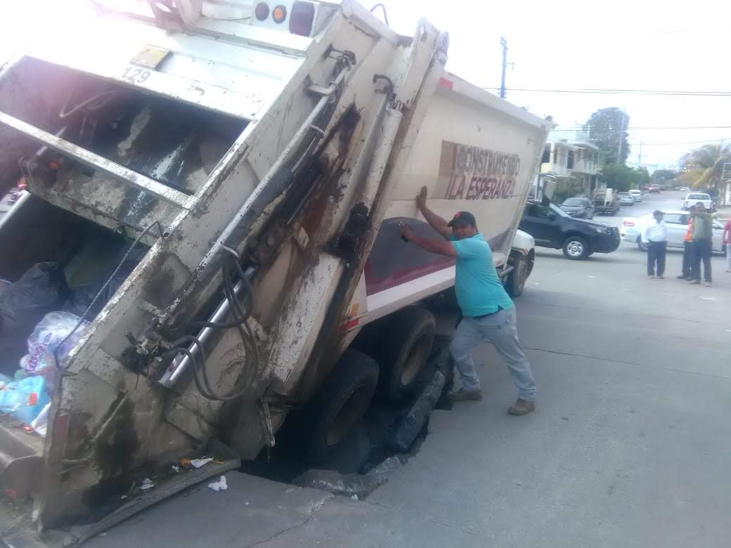 Cae camión de basura en socavón.