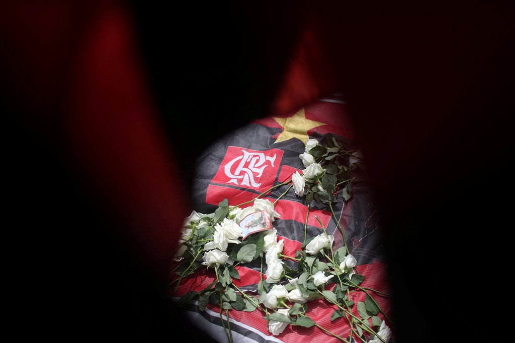 Dejan flores en la entrada del Club después del incendio que le costó la vida a 10 jóvenes (Reuters)