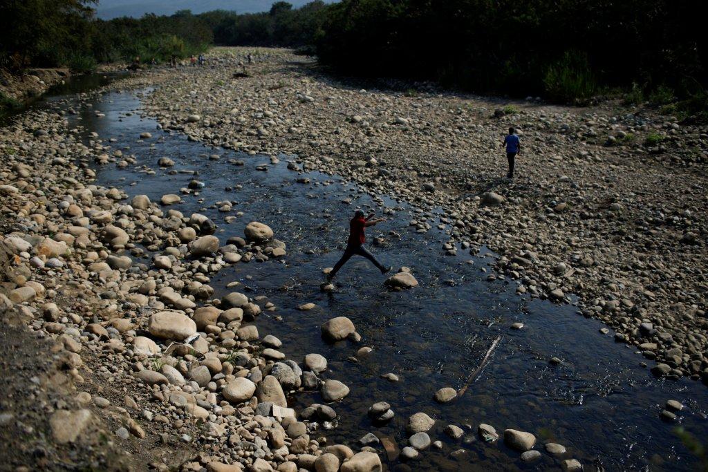 Venezuela. Un hombre cruza por el Río Táchira a Colombia tras los bajos caudales de la zona (Reuters)