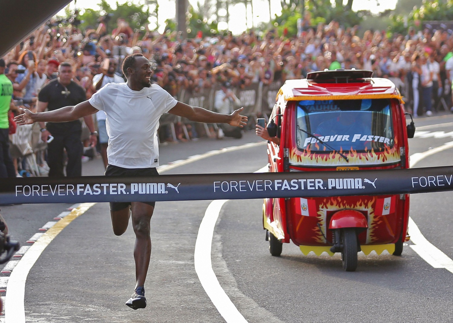 Trotando, Bolt ganó la carrera de 50 metros a un mototaxi. (AFP)