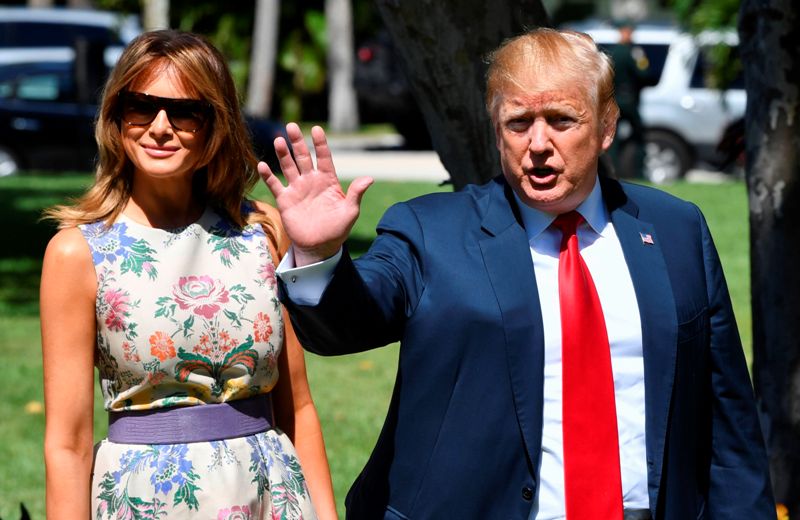 El mandatario acudió con un traje azul y corbata roja, mientras que Melania lo hizo con un vestido de flores y cinturón lila. (AFP)