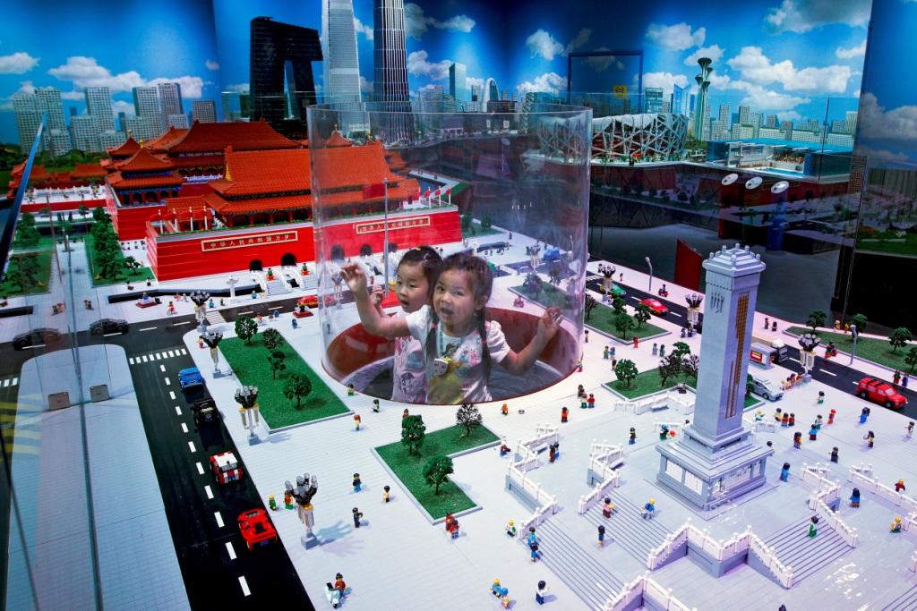 China. Un par de niñas observan en el panel la Plaza Tiananmen hecha de cubos Lego en la exposición Legoland Discovery Center en Beijing (AP)